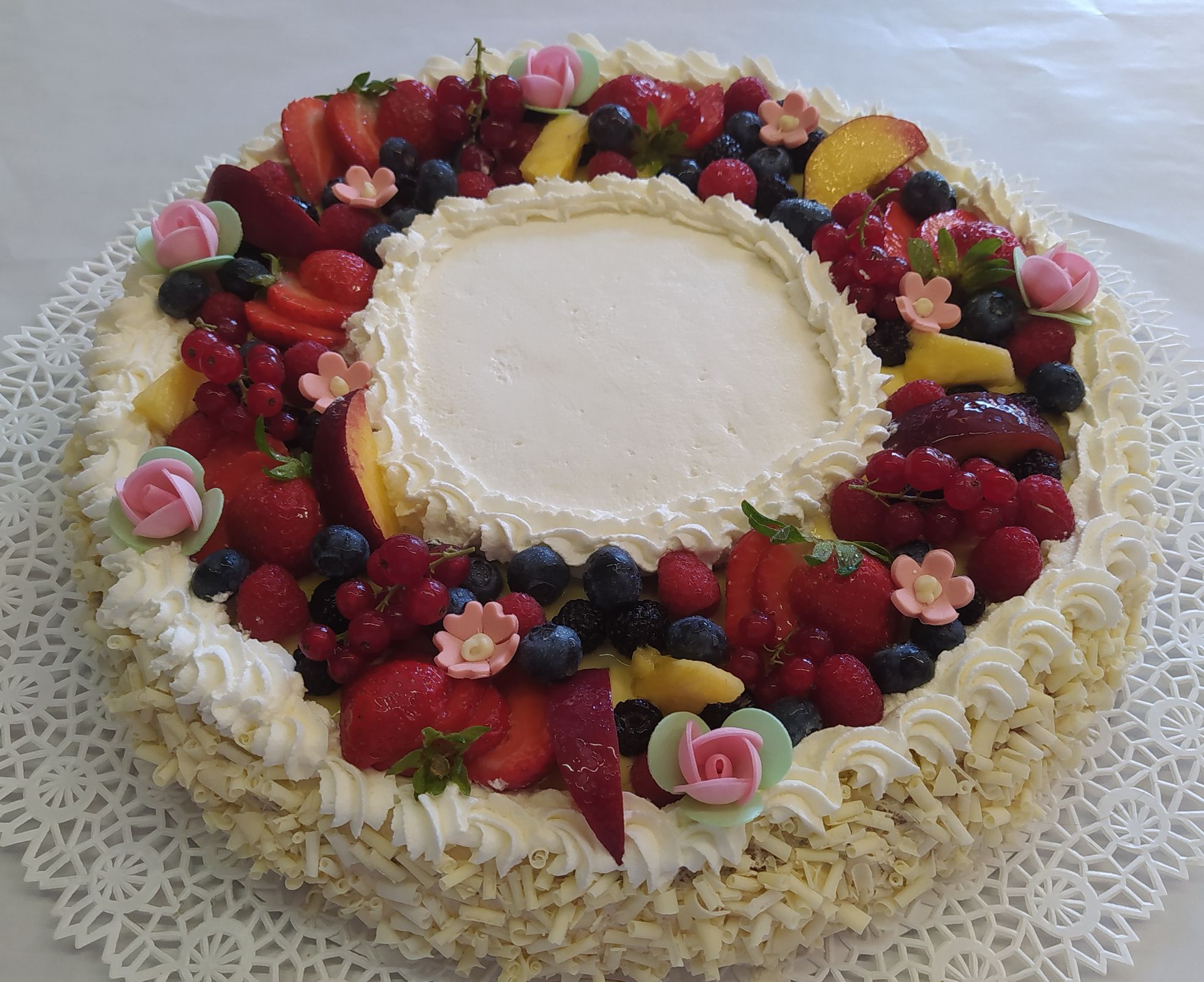 Torta con panna, pesche e frutti di bosco